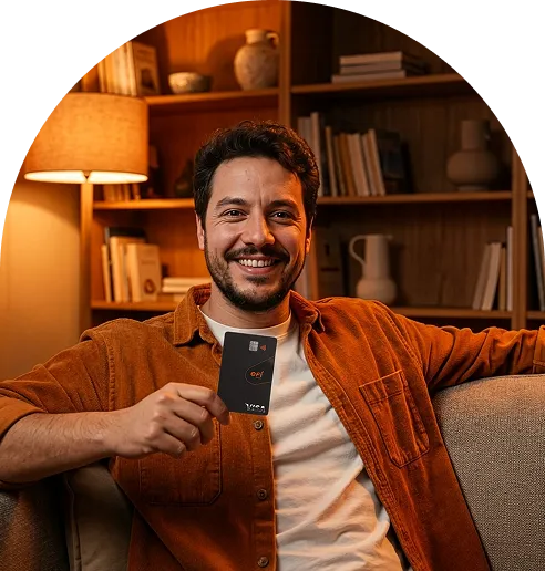 Pessoa sentada, sorrindo e exibindo cartão múltiplo do Efí Bank