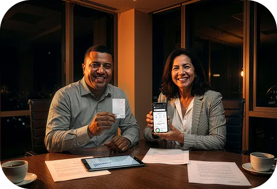 Homem sentado, sorrindo e segurando um celular